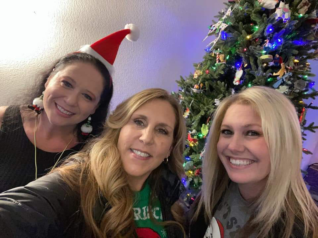 Friends enjoying the Ladies Christmas Social beside a Christmas tree